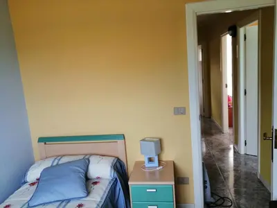 a bedroom with a bed and a desk with a computer on it at Urbanización Mar Cantábrico in Barreiros