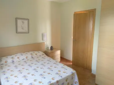 a bedroom with a bed and a wooden door at Urbanización Mar Cantábrico in Barreiros