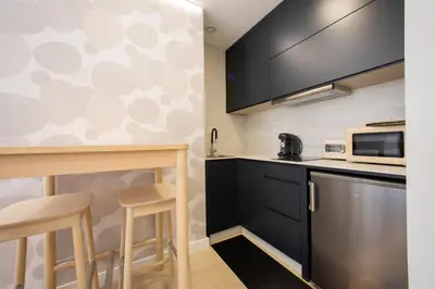 a kitchen with black cabinets and a microwave at Apartamentos O Devezo in Villalba