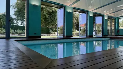an empty swimming pool in a house with windows at Pazo da Pena Manzaneda in Manzaneda