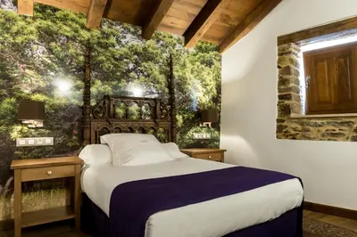 a bedroom with a bed and a wall mural at Pazo da Pena Manzaneda in Manzaneda
