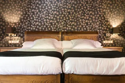 two beds sitting next to each other in a bedroom at Pazo da Pena Manzaneda in Manzaneda