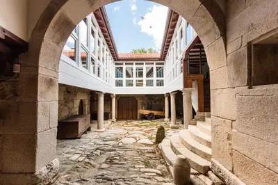 an old building with an archway and a stone courtyard at Pazo da Pena Manzaneda in Manzaneda