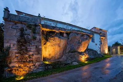 a stone building with lights on the side of it at Pazo da Pena Manzaneda in Manzaneda