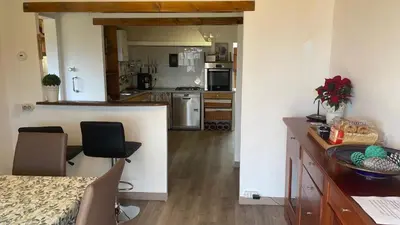 a kitchen with a counter and chairs in a room at casa teno in Parada de Achas