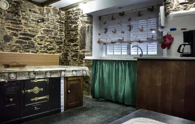 a kitchen with an old stove and a sink at Casa Mameleiro e Casa Kintal in A Pontenova