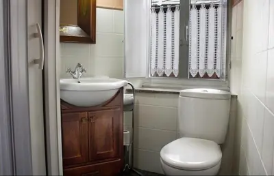 a bathroom with a toilet and a sink and a window at Casa Mameleiro e Casa Kintal in A Pontenova
