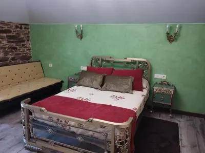 an old bed in a room with green walls at Casa Mameleiro e Casa Kintal in A Pontenova