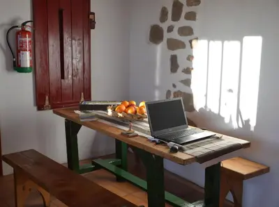 a laptop computer sitting on a wooden table in a room at Albergue a Casina di Marcello in Palas de Rei