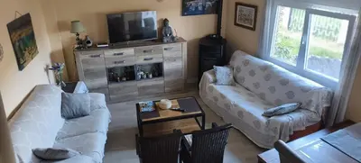 a living room with a couch and a tv at El Rincón del Cúa in Vega de Espinareda