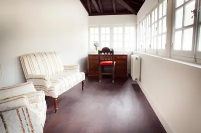 a room with two chairs and a desk and windows at Casona Puerto de Vega in Puerto de Vega