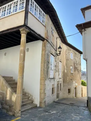 an old stone building with a stairway on the side at Casona Puerto de Vega in Puerto de Vega