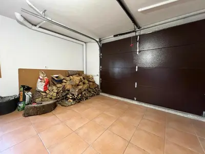 a garage with a large garage door and a pile of wood at YourHouse Fontevella II in Ourense