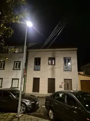two cars parked in front of a building with a street light at Sienna Home Apartamento in Santiago de Compostela