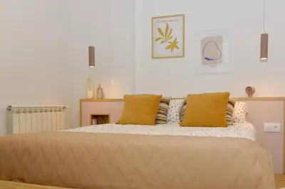a bedroom with a large bed with yellow pillows at Sienna Home Apartamento in Santiago de Compostela