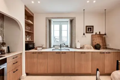 a kitchen with wooden cabinets and a window at Casa Do Gaiteiro in Melide