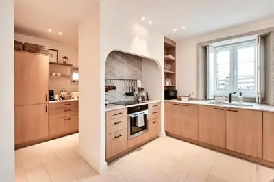 a large kitchen with wooden cabinets and a window at Casa Do Gaiteiro in Melide