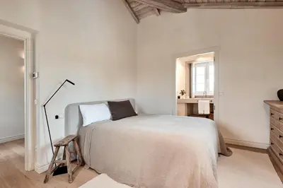 a white bedroom with a bed and a dresser at Casa Do Gaiteiro in Melide