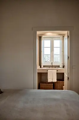 a bedroom with a bed and a sink and a window at Casa Do Gaiteiro in Melide