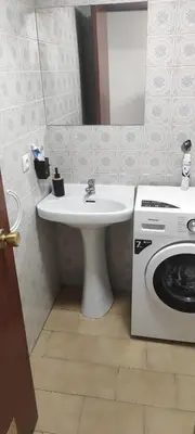 a bathroom with a sink and a washing machine at Cómo en casa Villablino in Villablino