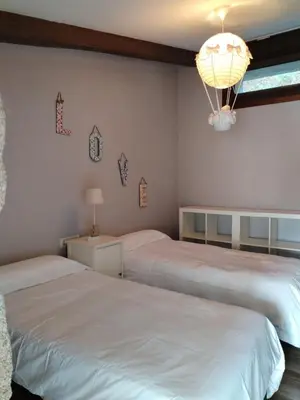 a bedroom with two beds and a chandelier at A Casa do outeiro in Ponteareas