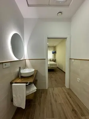 a bathroom with a sink and a mirror at Pensión María Castaña in Puebla del Brollón