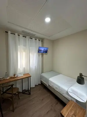 a bedroom with a bed and a desk and a television at Pensión María Castaña in Puebla del Brollón