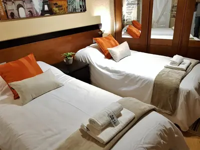 two beds in a hotel room with towels on them at Aqua Rooms Sarria in Sarria