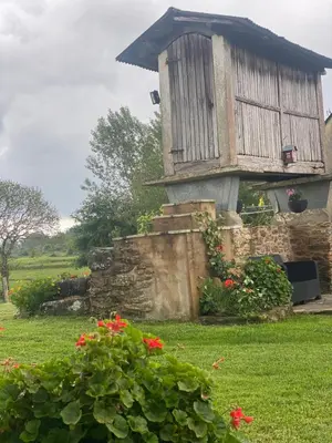 a house with a stone wall and red flowers at VUT Boente 2 in Boente