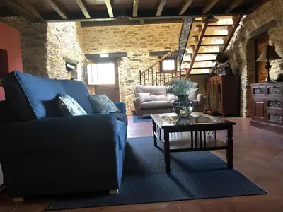 a living room with a blue couch and a coffee table at Hotel Rural Casona Trabadelo in Vegadeo