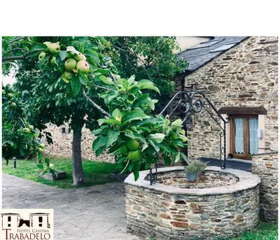 a apple tree in a stone planter in front of a building at Hotel Rural Casona Trabadelo in Vegadeo