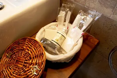 a basket of toothbrushes and toothpaste on a table next to a sink at Hotel Rural Casona Trabadelo in Vegadeo