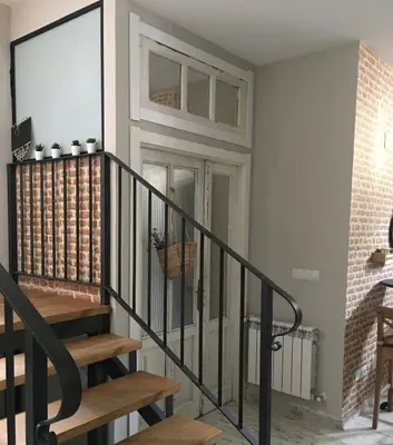 a staircase in a house with a brick wall at As Miguiñas do Cebreiro in Piedrafita