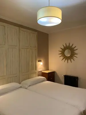 a bedroom with two white beds and a mirror at As Miguiñas do Cebreiro in Piedrafita