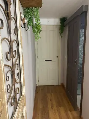 a hallway with a white door and a wooden floor at As Miguiñas do Cebreiro in Piedrafita