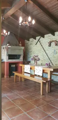 a room with two wooden benches and a fireplace at Apartamentos Rurales Casa Pachona in Puerto de Vega