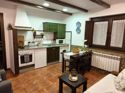 a kitchen with green cabinets and a table in a room at Apartamentos Rurales Casa Pachona in Puerto de Vega