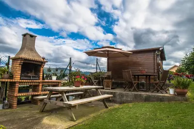a patio with a picnic table and a fireplace at Apartamentos Rurales Casa Pachona in Puerto de Vega