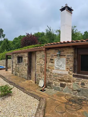a small stone building with a chimney on top at Casita Meu Pai in Boimorto