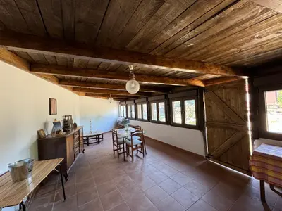 a living room with a wooden ceiling and a table at Casita Meu Pai in Boimorto