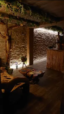 a dark room with a table and a stone wall at Casa Antón O Cebreiro in O Cebreiro