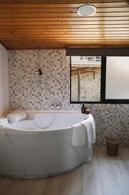 a large white bath tub in a bathroom with a window at Casa As Nogueiras in Deade