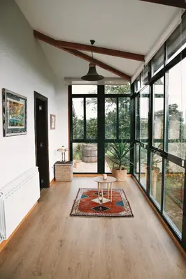 a living room with a table and large windows at Casa As Nogueiras in Deade