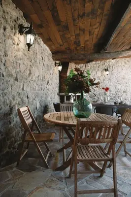 a wooden table and chairs with a vase on it at Casa As Nogueiras in Deade
