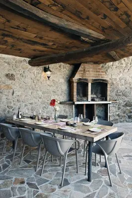 a large wooden table with chairs and a fireplace at Casa As Nogueiras in Deade