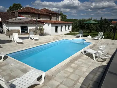 a villa with a swimming pool in front of a house at Casa As Nogueiras in Deade