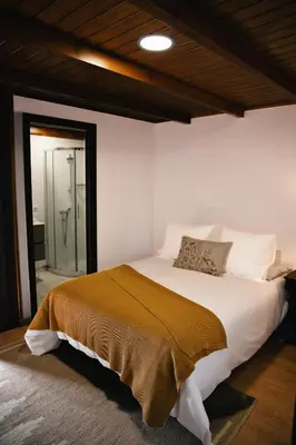 a bedroom with a large bed with a brown blanket at Casa As Nogueiras in Deade