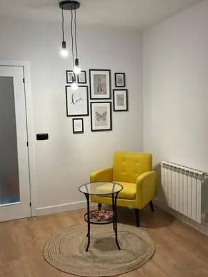 a living room with a yellow chair and a table at Joaquín Potel in Caldas de Reis