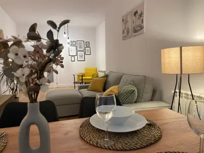 a living room with a table with a glass of wine at Joaquín Potel in Caldas de Reis
