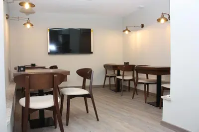 a room with tables and chairs and a flat screen tv at Xanela Xures in Muiños